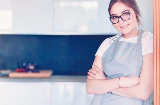 Young woman standing near desk in the kitchen .