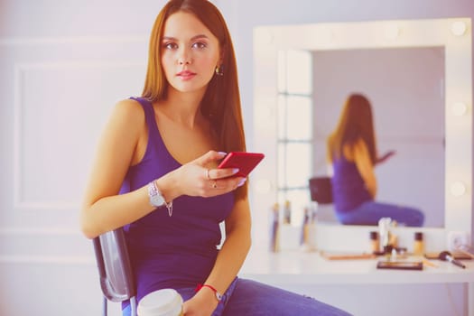 Young woman at cafe drinking coffee and talking on the mobile phone.