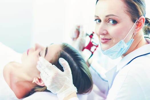 A young girl having red lips permanent makeup, micropigmentation.