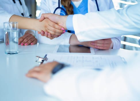 Doctor shakes hands with a patient isolated on white background.
