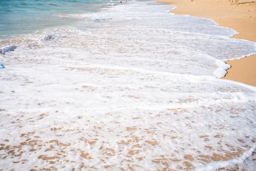 Soft beautiful ocean wave on sandy beach. Background. Turquoise color sea view with copy space