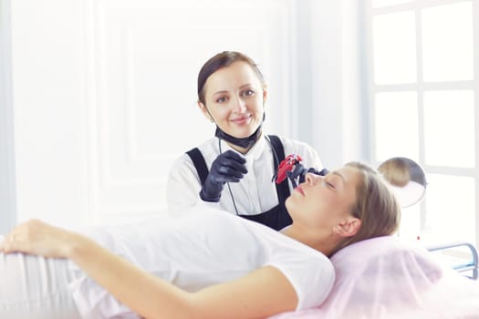 Cosmetologist applying permanent make up on eyebrows.