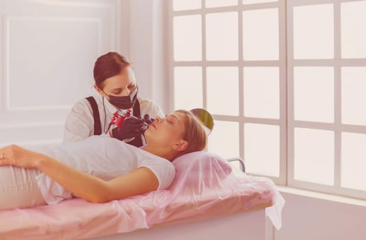 Cosmetologist applying permanent make up on eyebrows.