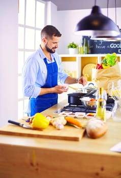 Man preparing delicious and healthy food in the home kitchen.