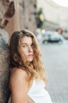 A stylish young girl with curly hair in a side portrait. High quality photo