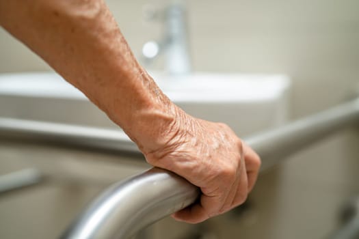 Asian elderly woman patient use toilet bathroom handle security in nursing hospital, healthy strong medical concept.