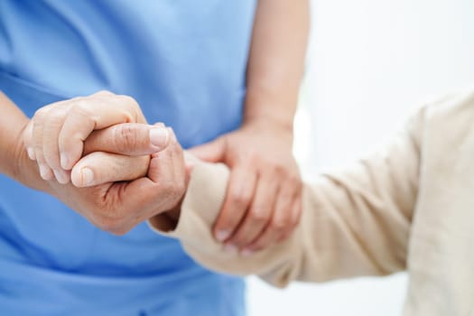 Doctor holding hands Asian elderly woman patient, help and care in hospital.