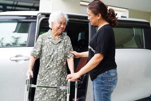 Caregiver help Asian elderly woman disability patient get in her car, medical concept.