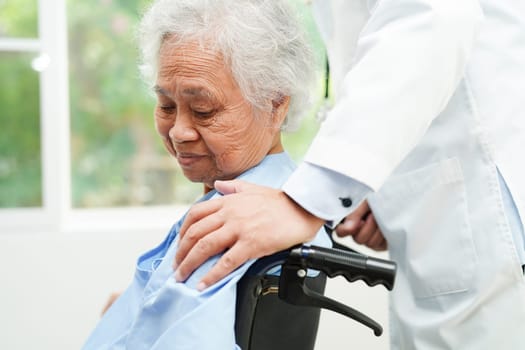 Doctor help Asian elderly woman disability patient sitting on wheelchair in hospital, medical concept.