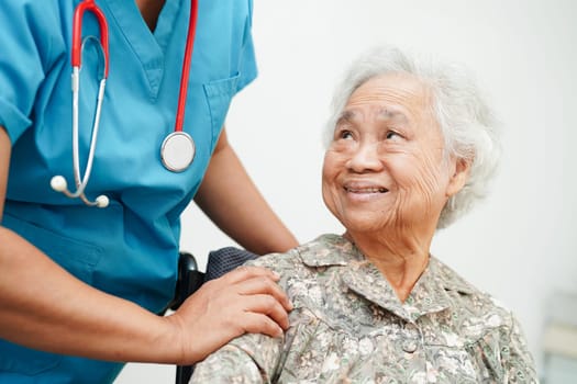 Doctor help Asian elderly woman disability patient sitting on wheelchair in hospital, medical concept.