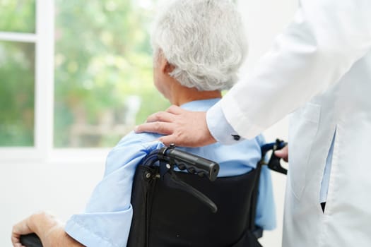 Doctor help Asian elderly woman disability patient sitting on wheelchair in hospital, medical concept.