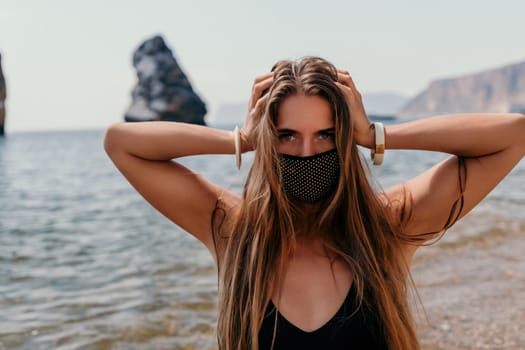 Woman travel sea. Young Happy woman in a long red dress posing on a beach near the sea on background of volcanic rocks, like in Iceland, sharing travel adventure journey