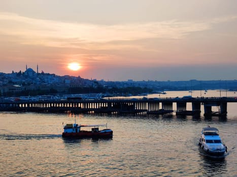 Ships and bridge across the Bosphorus in Istanbul at sunset.