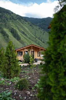 a wooden house outside the city in a mountainous area among trees.