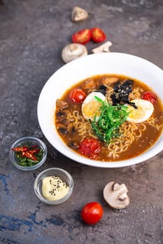 spicy traditional ramen with egg, mushrooms and seafood top view.