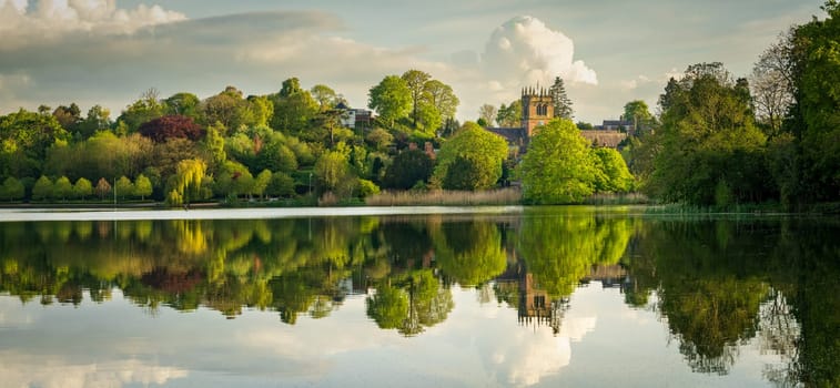 Panorama of town of Ellesmere in Shropshire with reflection view from across the Mere to the Church