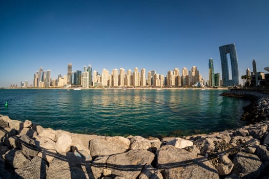 Wide panorama with fisheye lens of new apartments among hotels on oceanfront in Jumeirah Beach Residence area of Dubai