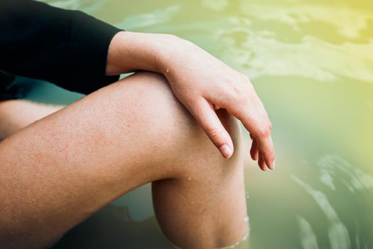 female hand and foot on a background of water