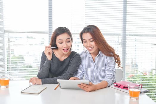 Happy young businesswoman talking to her colleague