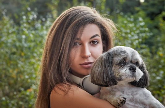 Oung woman with her cute Shih Tzu. Hugs a beautiful pet