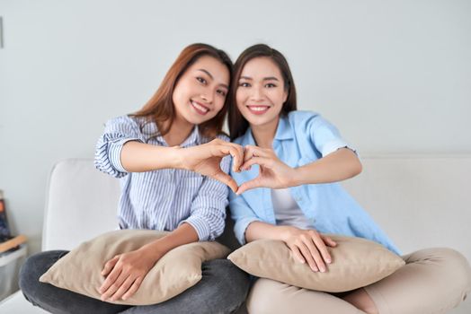 Girlfriends having fun, singing and playing together at home.