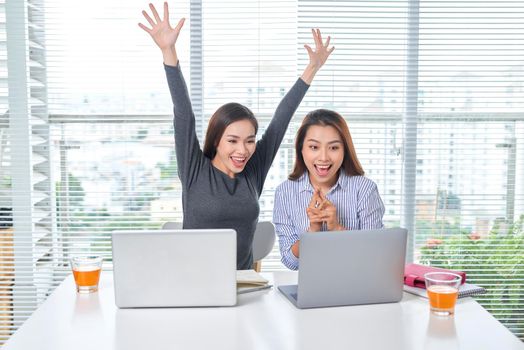 business, teamwork and people concept - female team or businesswomen with laptop computer working at office