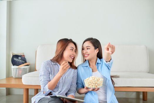 Happy girl friend watching tv at home.