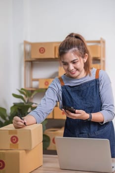 Startup small business entrepreneur SME, asian woman receive order on phone. Portrait young Asian small business owner home office, online sell marketing delivery SME e-commerce telemarketing concept..