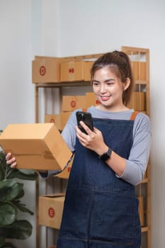 Startup small business entrepreneur SME, asian woman receive order on phone. Portrait young Asian small business owner home office, online sell marketing delivery SME e-commerce telemarketing concept..