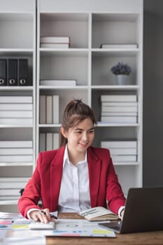 Business woman using calculator for do math finance on wooden desk in office and business working background, tax, accounting, statistics and analytic research concept