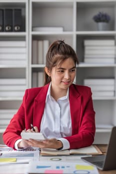 Business woman using calculator for do math finance on wooden desk in office and business working background, tax, accounting, statistics and analytic research concept