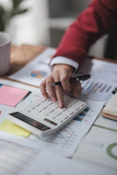 Asian female accountant or banker making calculations. Savings, finances and economy concept...