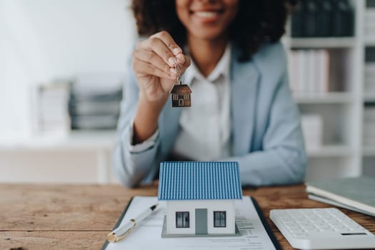 Real estate agent, African American businesswoman Africans use smartphone and calculators to offer mortgages to their clients. Home mortgage and insurance finance concepts