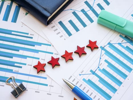 Business graphs and five stars as a symbol of high rating on them.