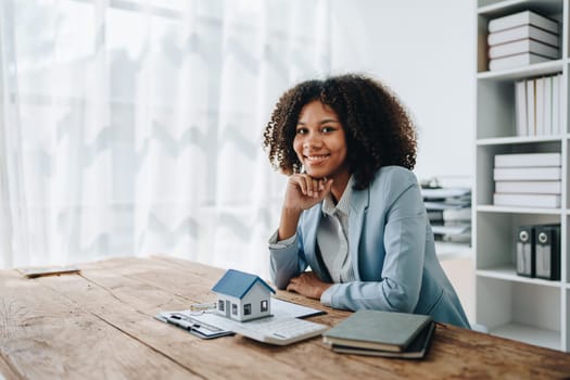 Real estate agent, African American businesswoman Africans use smartphone and calculators to offer mortgages to their clients. Home mortgage and insurance finance concepts