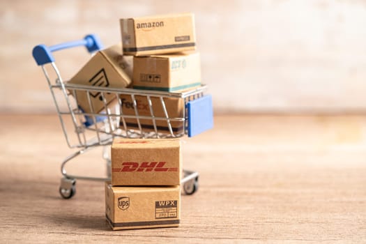 Bangkok, Thailand September 26, 2022 Shopping cart with DHL Amazon and FedEx express packing box, import export online exchange investment business.