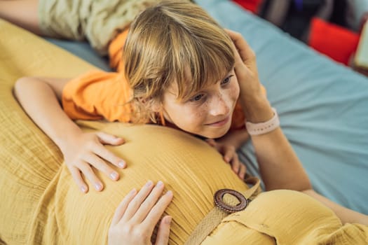 Young pregnant mother hugging her little boy lying in bed at night. Caring and loving parent hugging child.