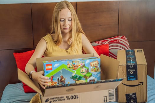 12.21.22, Mexico, Playa del Carmen: A pregnant woman received a package from Amazon. A woman takes a Lego set out of the box for her eldest son. Online shopping during pregnancy.