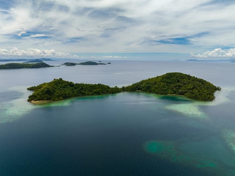 Aerial drone of islands with turquoise water and coral reef. Seascape in the tropics. Borneo, Sabah, Malaysia.