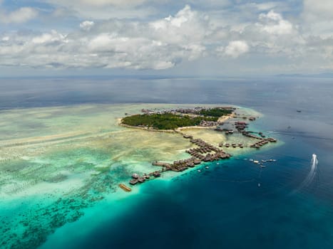 Aerial drone of tropical island of Mabul with a beautiful beach and coral reef. Semporna, Sabah, Malaysia.
