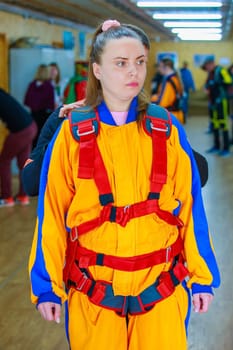 The instructor tightens the straps of the parachute suit. High quality photo