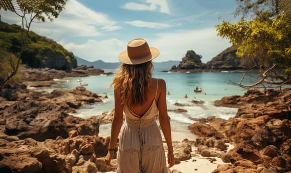 Stylish girl traveling back view looking at tropical ocean.Young woman wearing long dress and straw hat standing in sea water at the beach enjoying view in the summer Holiday Travel girls