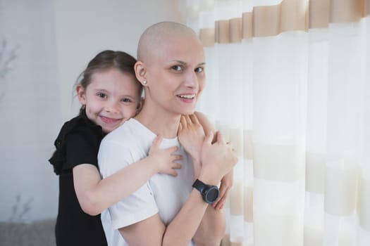 Young smiling woman with oncology. cancer patient spending time with her child at home. Cancer and family support concept.