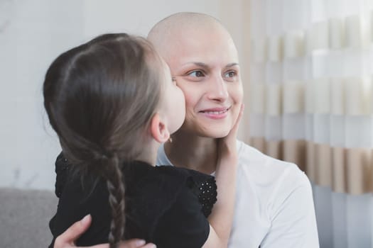 Smiling woman with oncology spending time with her child at home. Cancer and family support concept.