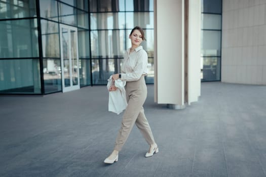 Beautiful caucasian blond woman going to job in office building, Calm beige business style.