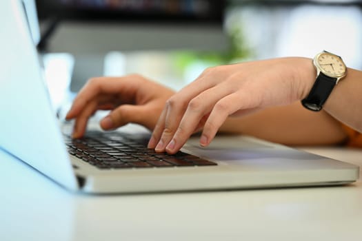 Unrecognizable woman hands typing on laptop keyboard, working in office or browsing information.