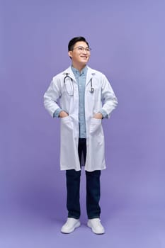 Handsome young man wearing doctor uniform with a happy and cool smile on face