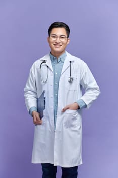 A handsome doctor wearing white lab coat and stethoscope smiling friendly and posing with his folder