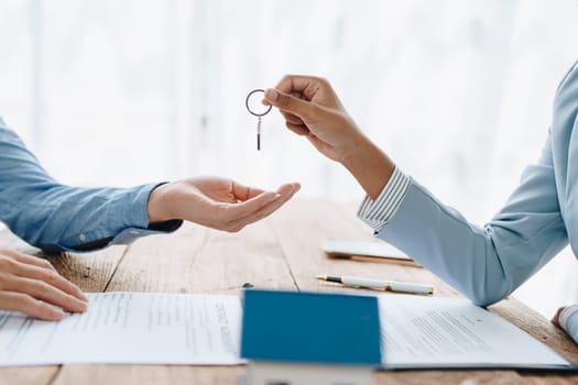 Female African american Real estate company to buy houses and land are delivering keys and houses to customers after agreeing to make a home purchase agreement and make a loan agreement