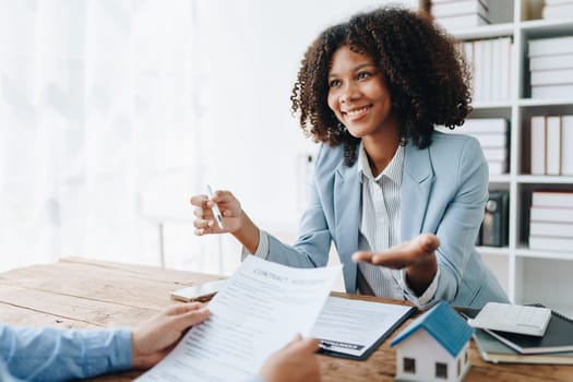 Real estate african american are delivering keys and houses to customers after agreeing to make a home purchase agreement and make a loan agreement or insurance.